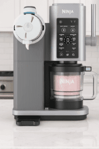 Ninja Swirl by CREAMi ice cream maker on modern kitchen counter dispensing soft serve