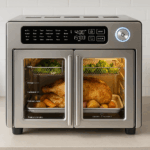 Emeril Lagasse stainless steel air fryer countertop oven with dual doors cooking chicken and vegetables