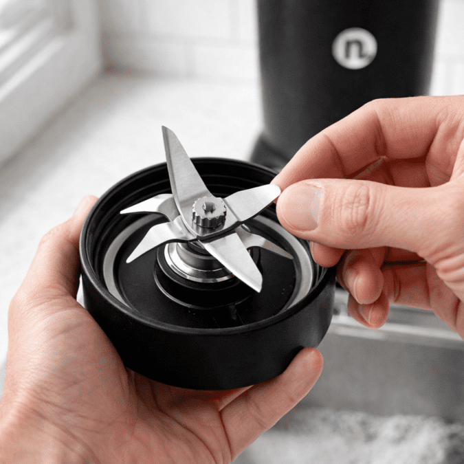 NutriBullet RX extractor blade close up stainless steel blades held in hand showing sharpness and build quality