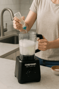 A person cleaning a Chefman Obliterator blender after use in a modern kitchen